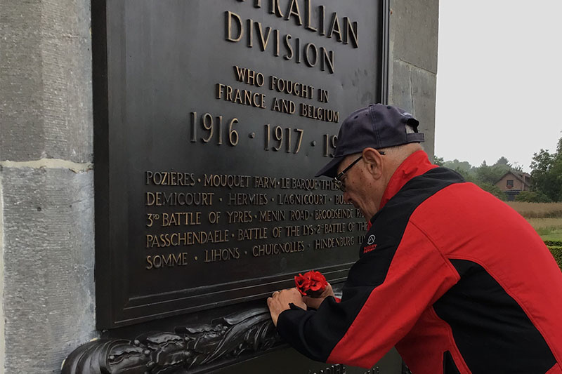 Placing red poppies on a WWI memorial