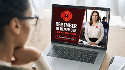 Person looking at a laptop with Remember to Remember poster. 