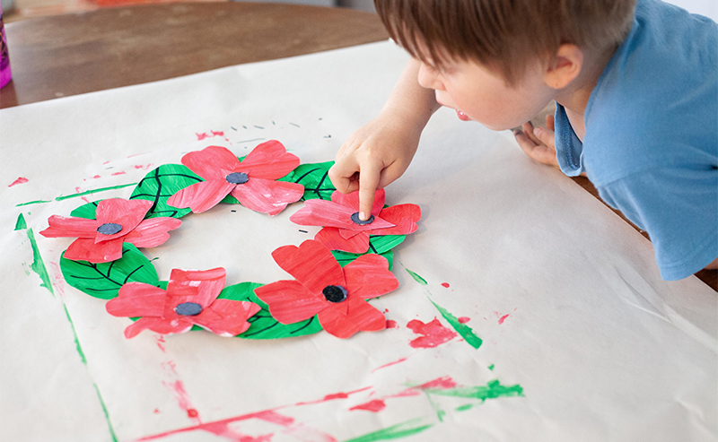 Child making a poppy wreath